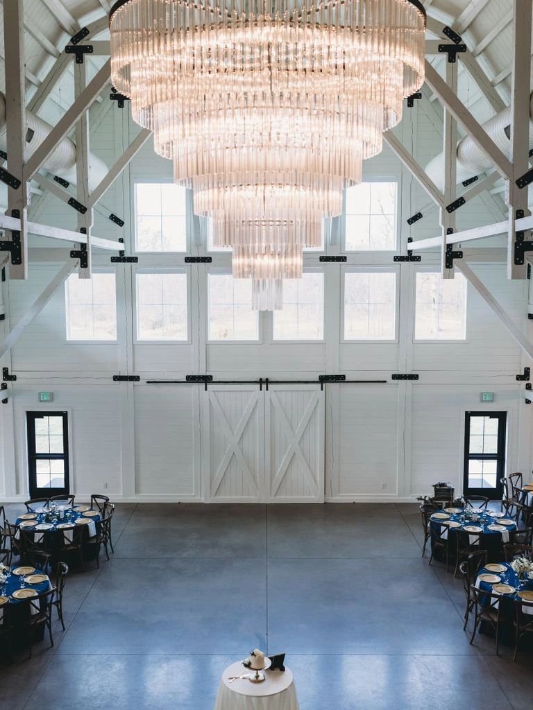 A long reception table styled with layered linen, brass tapers, and handblown glassware.